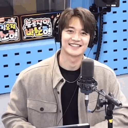 Man in Headphones Smiling at Microphone in Radio Studio