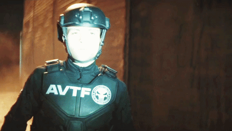 Man in Helmet and AVTF Jacket Holding Up Hand