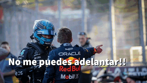 Man in Helmet and Red Bull Shirt Pointing at Another Man