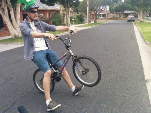Man in Helmet and Sunglasses Riding Bicycle