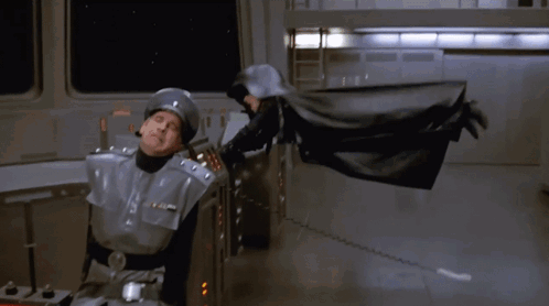 Man in Helmet Next to Man in Black Suit