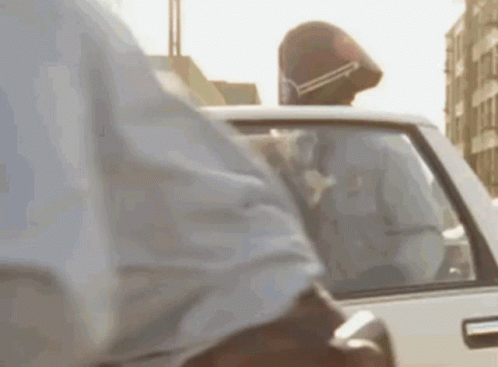 Man In Helmet Sitting In Back Seat Of White Car GIF