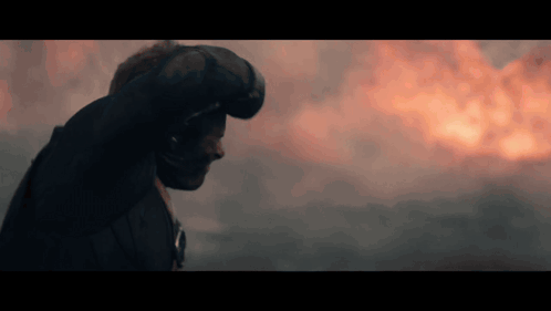 Man in Helmet Standing Before Fire
