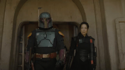 Man In Helmet Standing Next To Woman In Black GIF