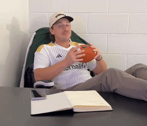 Man in Herbalife Jersey Holding Football