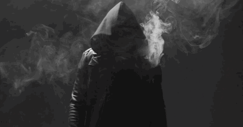 Man In Hood Smoking Electronic Cigarette In Dark GIF