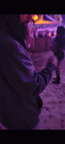 Man in Hooded Jacket in Front of Purple Lights