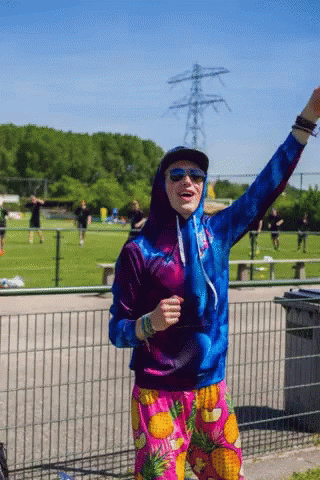 Man in Hoodie and Pineapple Shorts in Field