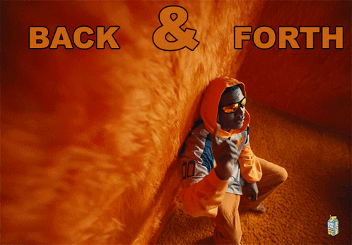 Man in Hoodie Sitting by Orange Wall