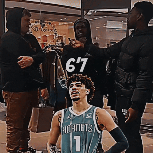 Man In Hornets Jersey With Group Of Men GIF