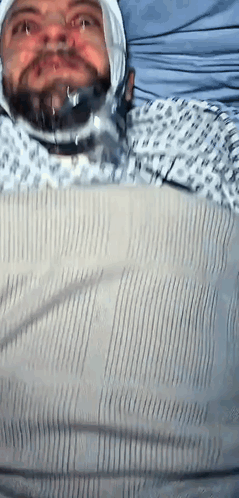 Man in Hospital Gown With Bandage on Head