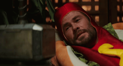 Man in Hot Dog Costume Laying on Pillow