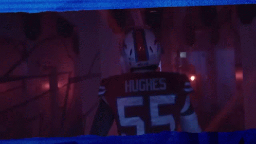 Man in Hughes Jersey Standing in Dark Room