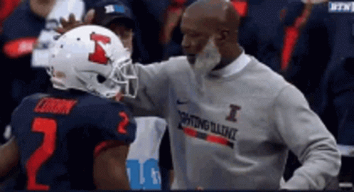 Man in I Sweatshirt Talking to Football Player