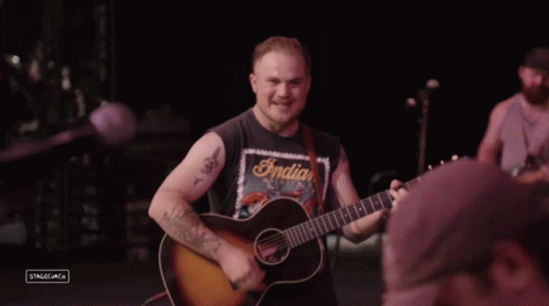 Man in Indian Motorcycles Shirt Playing Guitar