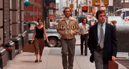 Man In Jacket Saying Good Walking Down Street GIF