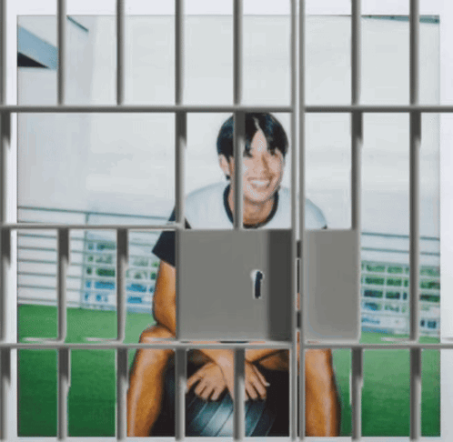 Man in Jail Cell Behind Bars