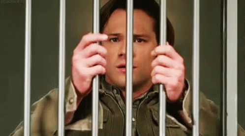 Man In Jail Cell Holding Bars GIF