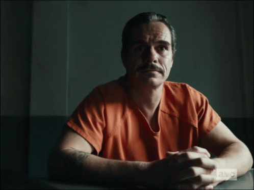 Man in Jail Cell with Money on Arm