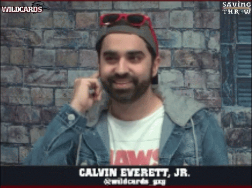 Man in Jaws Shirt and Denim Jacket Talking on Phone