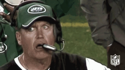 Man In Jets Hat And Headphones Looking At Camera GIF