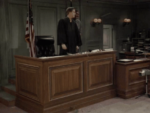 Man in Judge Robe Holding Gavel in Courtroom