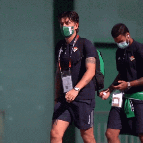 Man in Kappa Shirt Walking With Masked Man