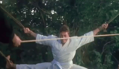 Man in Karate Uniform Doing Split with Rope