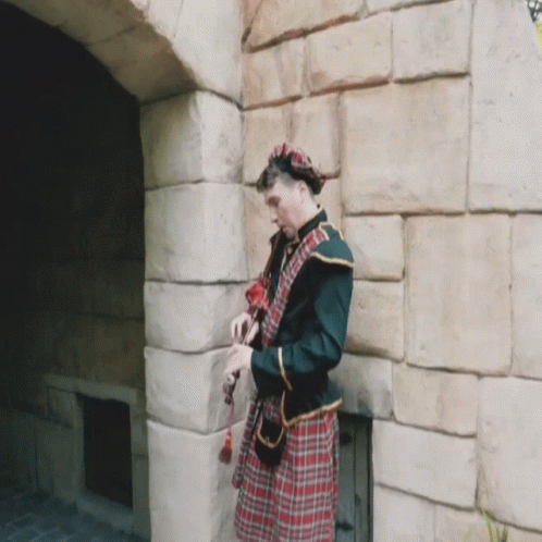 Man in Kilt by Stone Wall