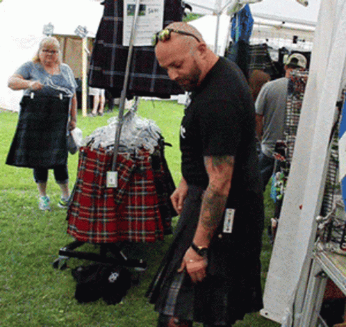 Man in Kilt in Front of Kilt Display