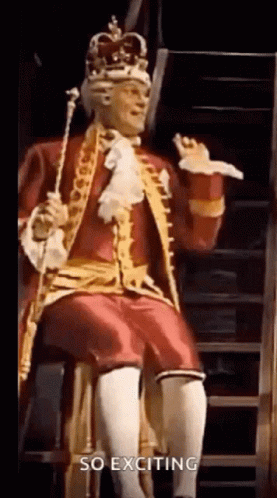 Man in King Costume Sitting on Staircase Holding Cane