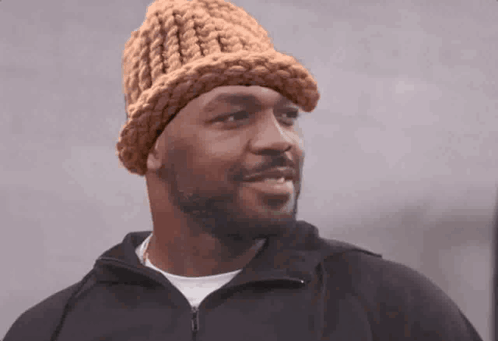 Man in Knitted Hat and Black Jacket Looking at Camera