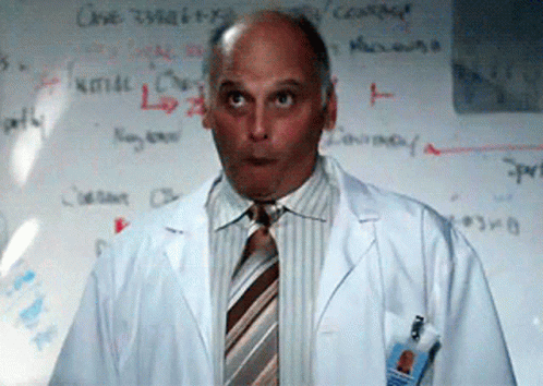 Man in Lab Coat and Tie at Whiteboard Saying Cause