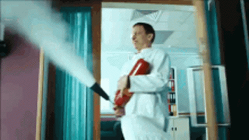 Man In Lab Coat Holding Fire Extinguisher GIF