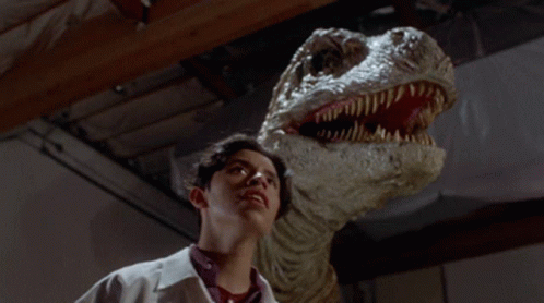 Man in Lab Coat Looking at Dinosaur
