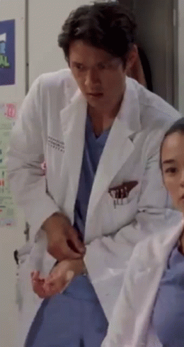 Man in Lab Coat Next to Woman in Scrubs