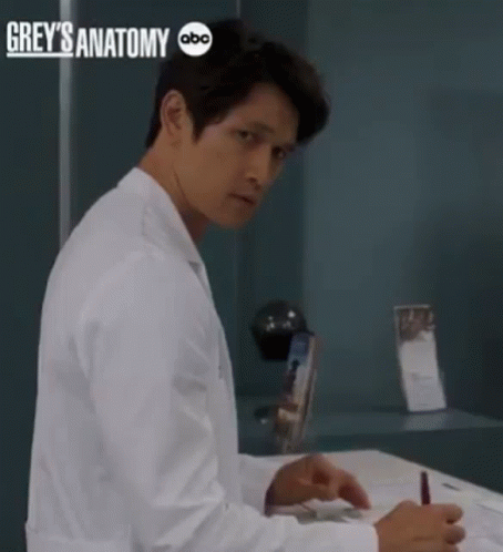 Man in Lab Coat Sitting at Desk with Grey's Anatomy ABC