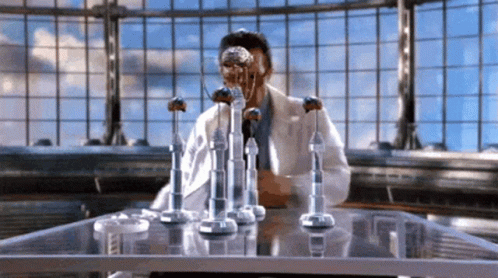 Man In Lab Coat Sitting At Table GIF