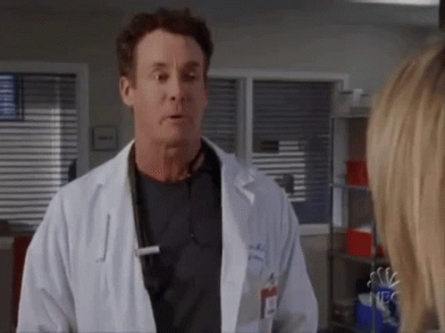 Man in Lab Coat Talking to Woman