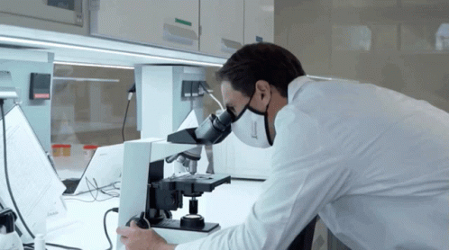 Man In Lab Coat Using Microscope With Mask GIF