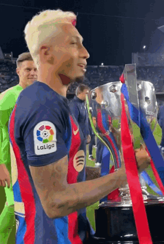 Man in LaLiga Shirt Holding Trophy