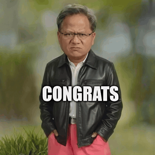 Man in Leather Jacket and Pink Pants in Front of Congrats Sign
