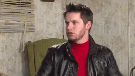 Man In Leather Jacket And Red Sweater Sitting In Chair GIF
