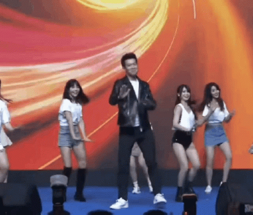 Man in Leather Jacket Dancing With Group of Girls