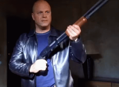 Man in Leather Jacket Holding Shotgun