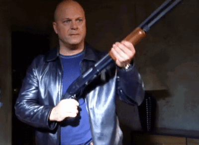 Man in Leather Jacket Holding Shotgun