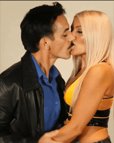 Man in Leather Jacket Kissing Blonde Woman in Yellow