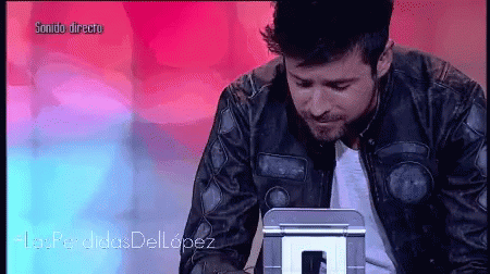 Man in Leather Jacket Looking at Sonido Directo Screen