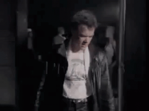 Man in Leather Jacket Standing in Dark Room