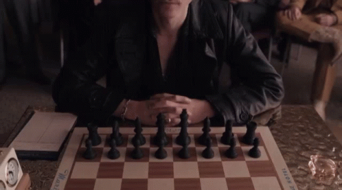 Man in Leather Jacket With Chess Board